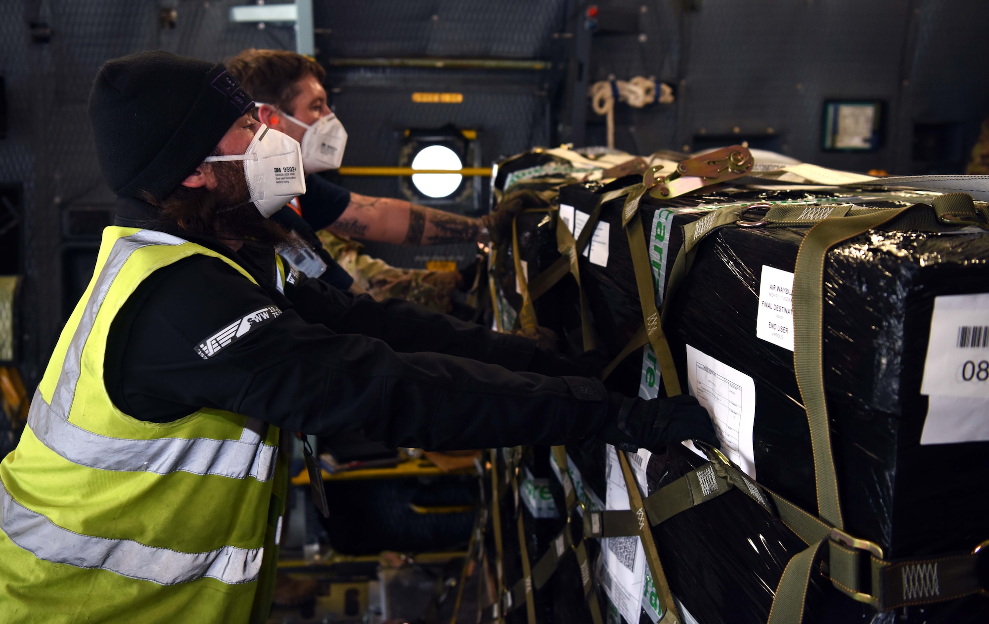 Contractors from the 727th Air Mobility Squadron, RAF Mildenhall, England, secure pallets of cargo aboard a C-5 Super Galaxy assigned to the 9th Airlift Squadron, Dover Air Force Base, Delaware, during a medical cargo mission at RAF Mildenhall, April 18, 2020. The 727th AMS and 9th AS took part in a mission which involved delivering COVID-19 test kits and other equipment to Accra, Ghana, to be distributed throughout the U.S. African Command area of responsibility. (U.S. Air Force photo by Senior Airman Brandon Esau)