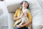 Image of a woman playing with her dog.