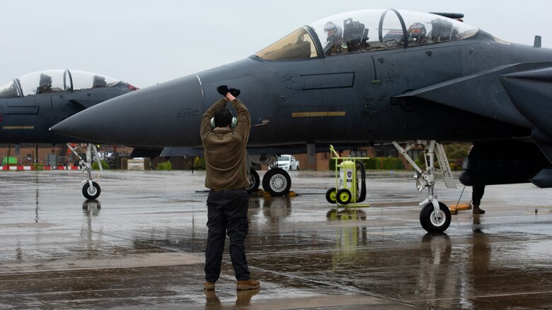 A 48th Maintenance Group crew chief signals to aircrew following a training flight at Royal Air Force Lakenheath, England, April 28, 2020. The 48th Fighter Wing continues to maintain mission-readiness in order to safeguard U.S. national interests and those of our allies and partners, despite the current COVID-19 crisis. (U.S. Air Force photo by Airman 1st Class Jessi Monte)