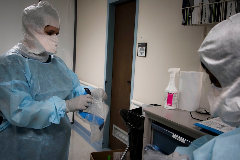 Nurses put on personal protective equipment.