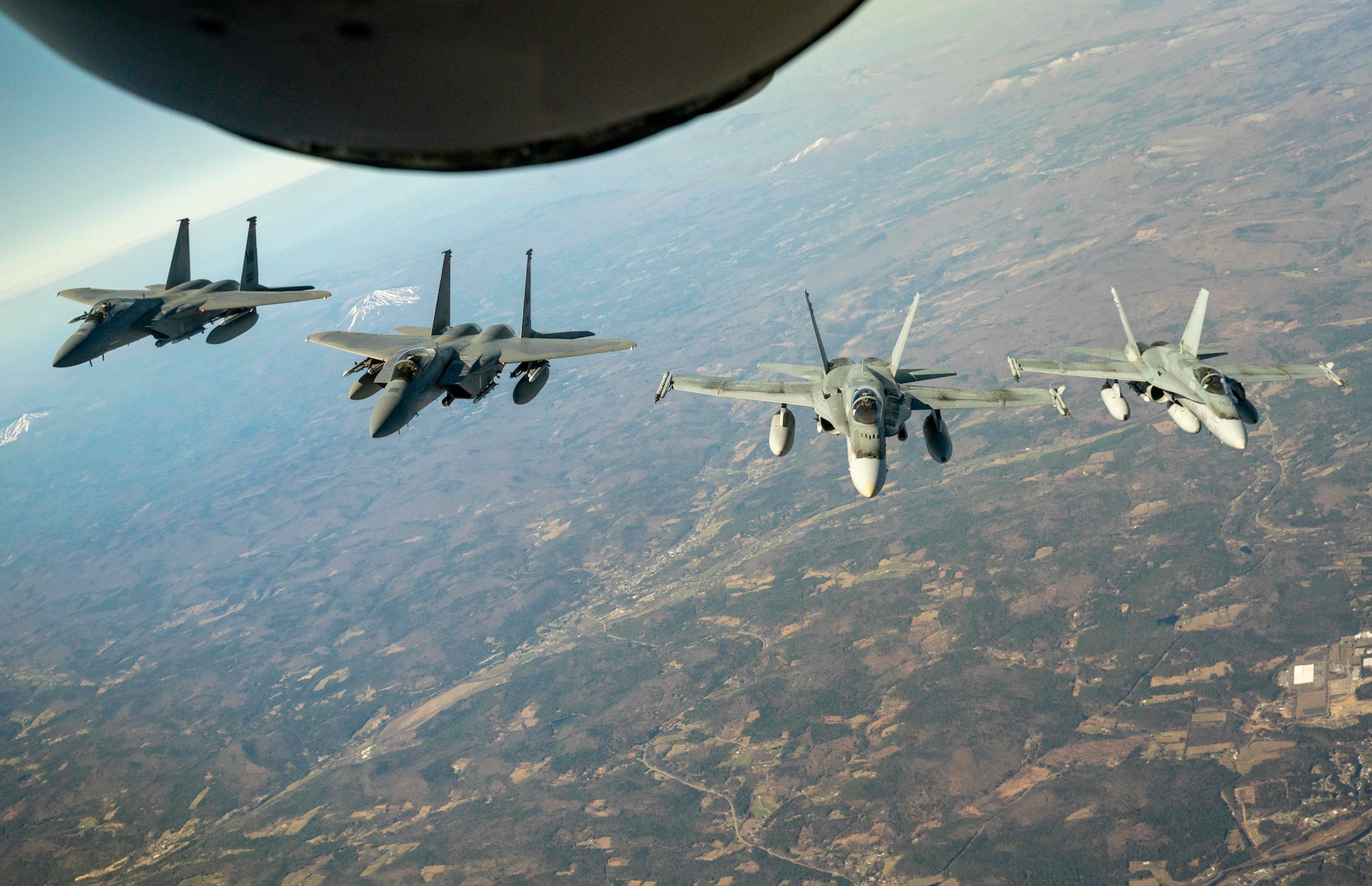 U.S. Air Force F-15 fighters jets from Massachusetts Air National Guard’s 104th Fighter Wing, and Royal Canadian Air Force CF-18 fighter jets from 3 Wing, Bagotville, Quebec fly in formation with a Pennsylvania Air National Guard KC-135 Stratotanker from the 171st Air Refueling Wing during a Continental U.S. North American Aerospace Defense Command Region and Canadian NORAD Region cross-border demonstration, April 23, 2020. Aircrew and members of the Air National Guard and Royal Canadian Air Force practiced tactical-intercept skills in an air defense exercise designed to reinforce interoperability across the United States and Canadian border.  A bi-national Canadian and American command, NORAD employs a network of space-based, aerial and ground-based sensors, air-to-air refueling tankers, and fighter aircraft, controlled by a sophisticated command and control network to deter, detect and defend against aerial threats that originate outside or within North American airspace. (U.S. Air National Guard Photo courtesy of Capt. Kyle Tufts)