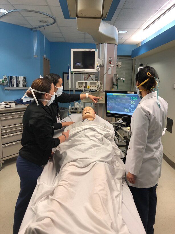 Intensive Care Unit Certified Nurse Specialist instructor LCDR Elaine Medley (right) assigned to Naval Medical Center Portsmouth instructs Major Joanna Bailey and 1st Lieutenant Kristin Salcedo assigned to McDonald Army Health Center in simulated training on how to administer respiratory care to a COVID-19 positive patient with increasing respiratory distress in preparation to support the medical center during the USS Comfort’s deployment in the fight against the COVID-19 pandemic.