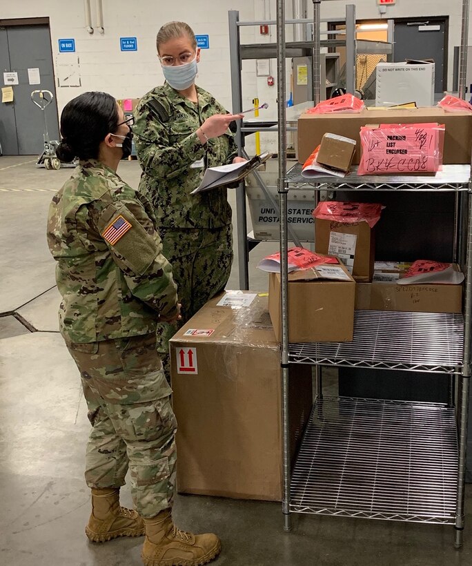 U.S. Navy Logistics Specialist Third Class Alexis Hemker trains Specialist Julie Hale assigned to McDonald Army Health Center on customer retrieving processes practiced at Naval Medical Center Portsmouth’s Medical Supply and Logistics Department.
