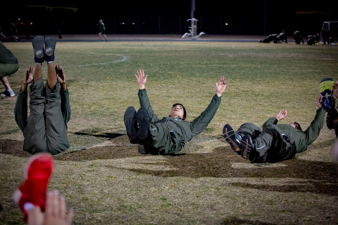 U.S. Marines and Sailors assigned to Headquarters and Headquarters Squadron (H&HS) participate in a squadron physical training (PT) session on Marine Corps Air Station (MCAS) Yuma, Ariz., Jan. 10, 2020. The PT session consisted of: burpees, crunches, flutter kicks, squats and running laps around the track. (U.S. Marine Corps photo by Lance Cpl. Gabrielle Sanders)