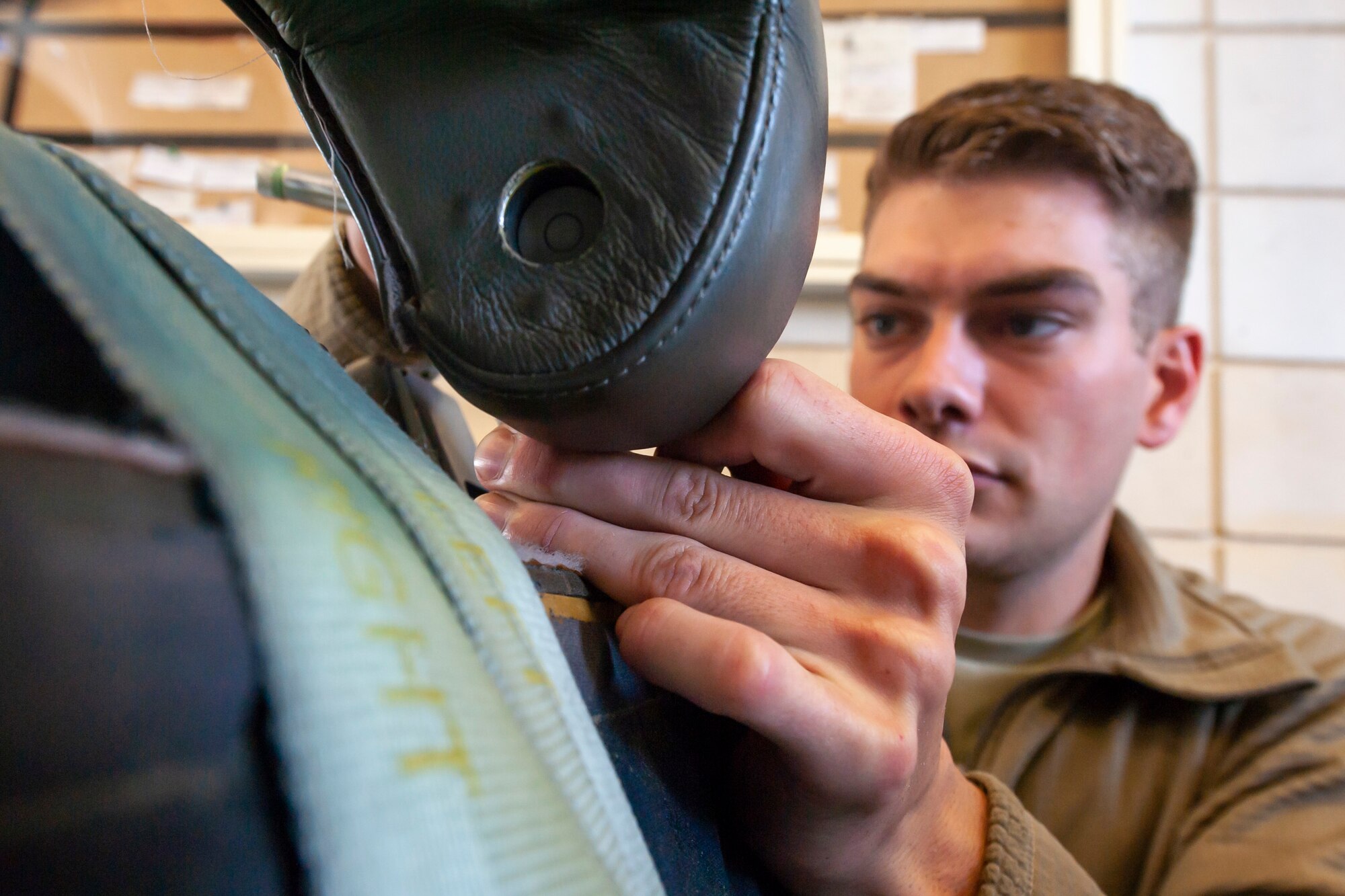A photo of an Airman unscrewing a headrest