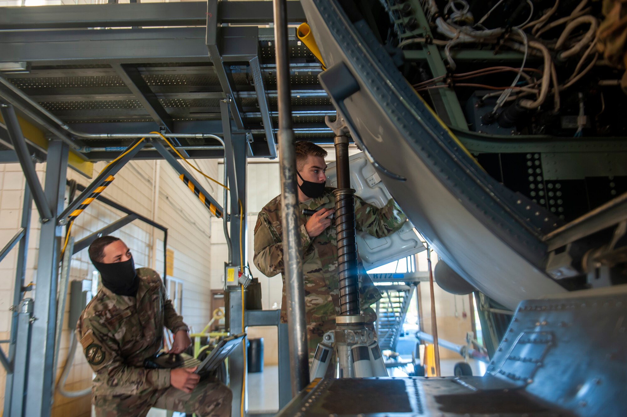 A photo of Airmen looking into an aircraft
