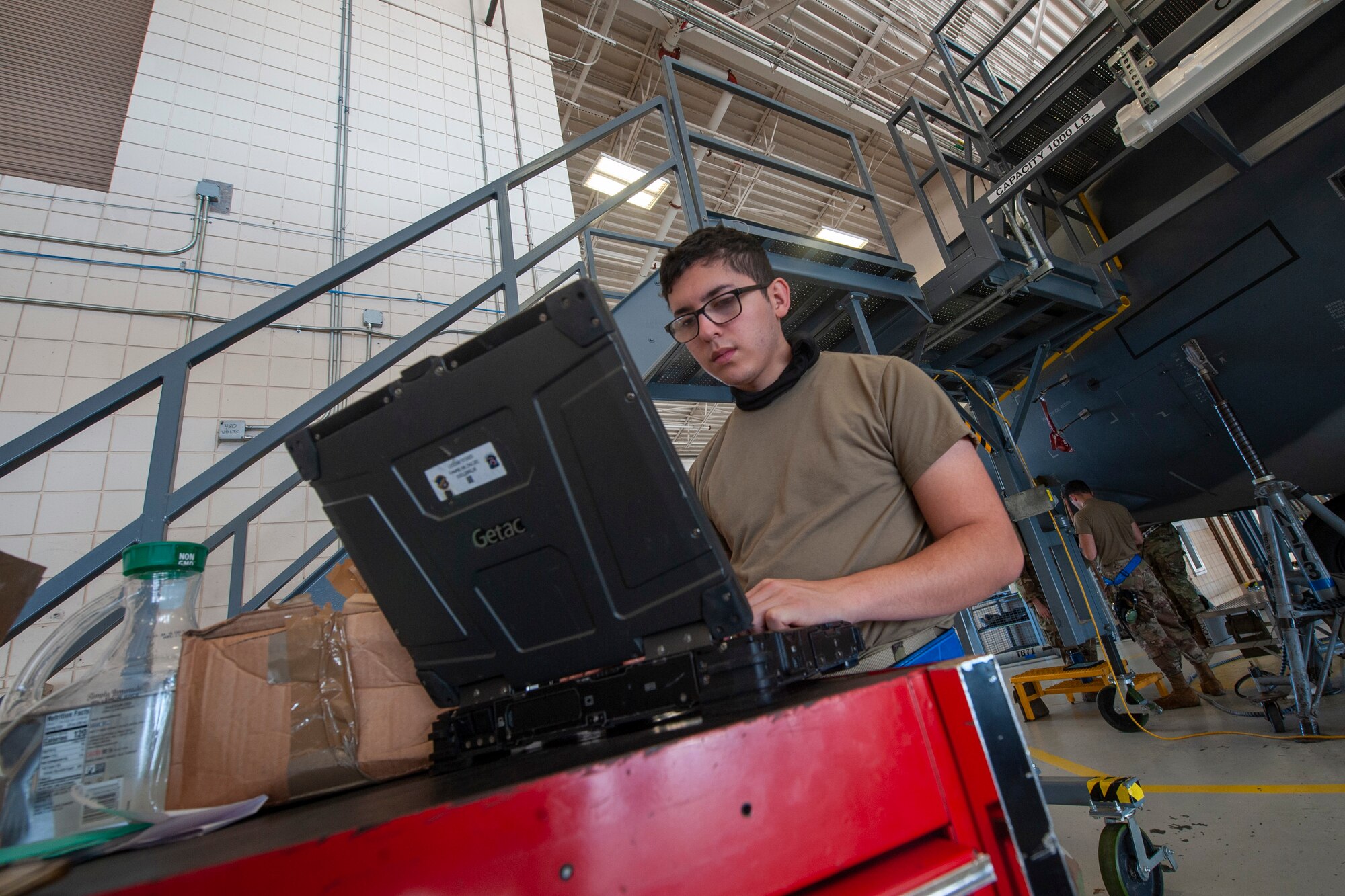 A photo of an Airman looking at a laptop