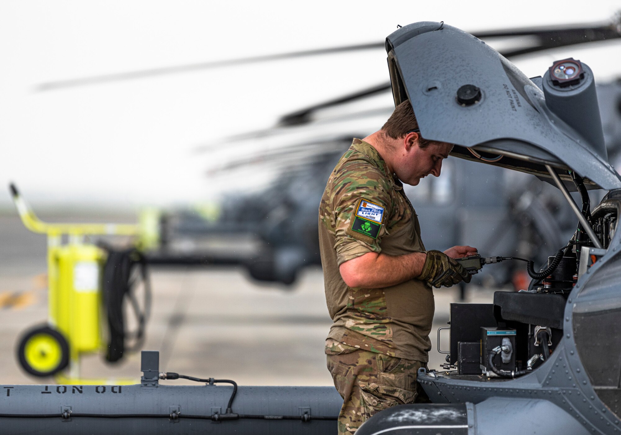 Photo of an Airman loading codes to an HH-60G Pave Hawk before a flight.