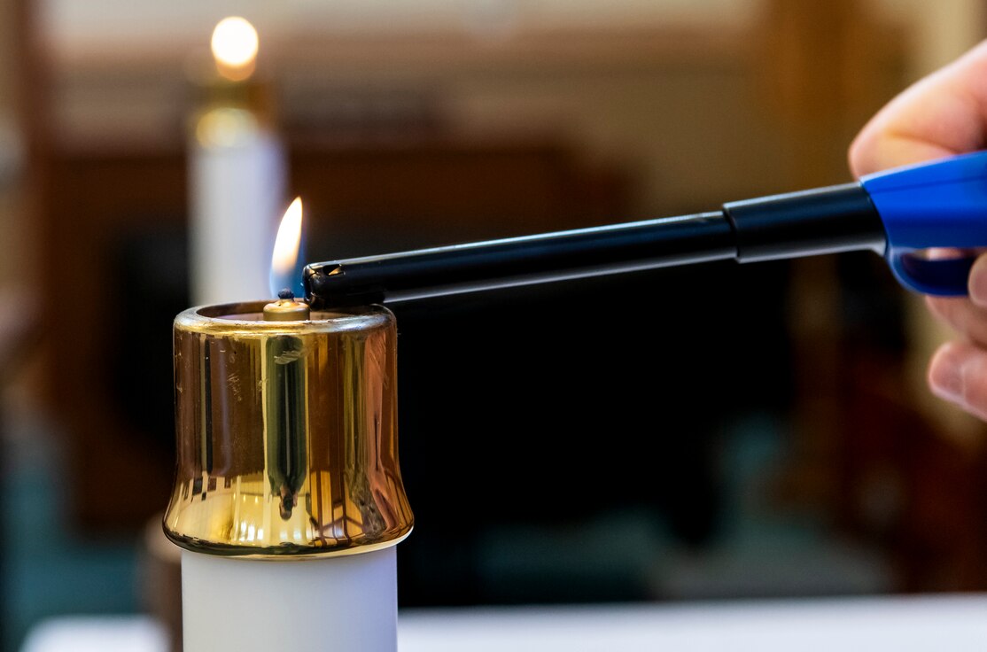 A chaplain lights a candle before recording a Sunday service April 25, 2020, at Dover Air Force Base, Delaware. Due to base and state shelter-in-place orders, Dover AFB chaplains pre-recorded services during the week and posted them to social media sites on traditional days of worship. These virtual services allow members of Team Dover to participate from the comfort and safety of their homes. (U.S. Air Force photo by Senior Airman Christopher Quail)
