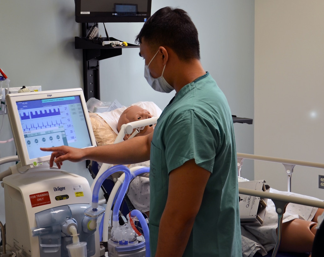 Sgt. Christian Paras checks his "patient's" ventilator settings