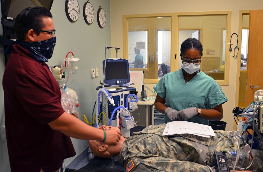 Sgt. Jasmin Fabre, a phase 2 student and Miguel Calvillo, a phase 2 instructor in the Medical Education and Training Campus Respiratory Therapist program, review a "patient's" medical information before deciding on a next course of action.