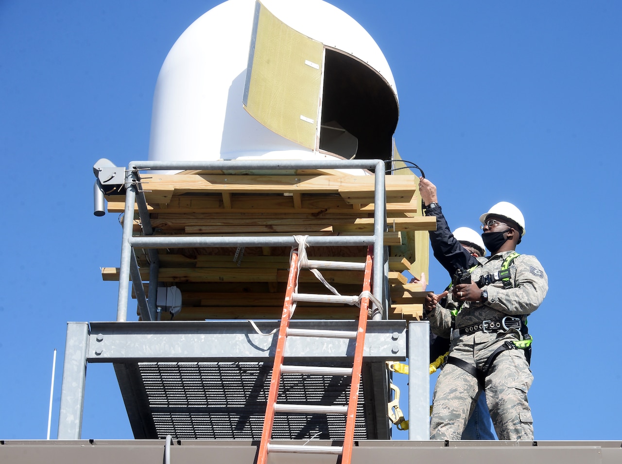 Men work on a satellite terminal.