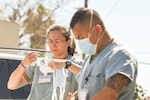 U.S. Army Spc. Makayla Montz and Pfc. Marc Jules Ocampo, California National Guard medical support team members, prepare to work at a skilled nursing facility in Southern California April 29, 2020. The medical support team is supporting staff at the facility, sharing best practices, and providing patient care for non-COVID-19 patients.