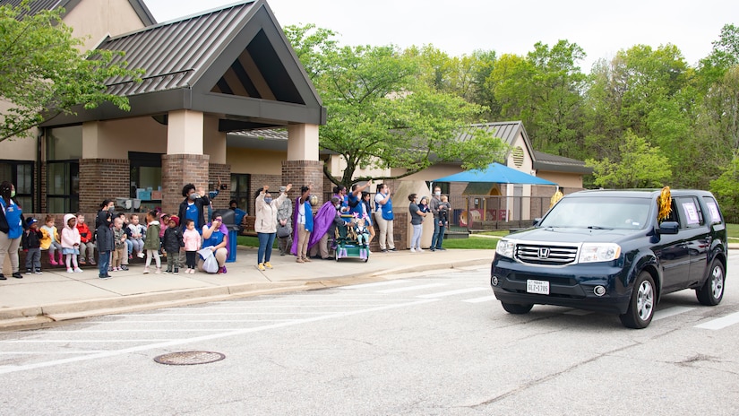 Child-care providers and children from Child Development Center 2 wave as a Month of the Military Child parade drives past on Joint Base Andrews, Md., April 24, 2020. The MotMC is an appreciation month where military families and their children are applauded for the efforts and sacrifices they make at home while their loved ones are out serving their country. (U.S. Air Force photo by Staff Sgt. Jared Duhon)