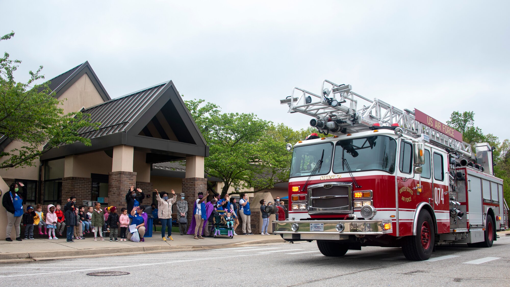 Child-care providers and children from Child Development Center 2 wave as a Month of the Military Child parade drives past on Joint Base Andrews, Md., April 24, 2020. The parade traveled through JBA’s base housing to show support for children who have parents serving in the military. (U.S. Air Force photo by Staff Sgt. Jared Duhon)