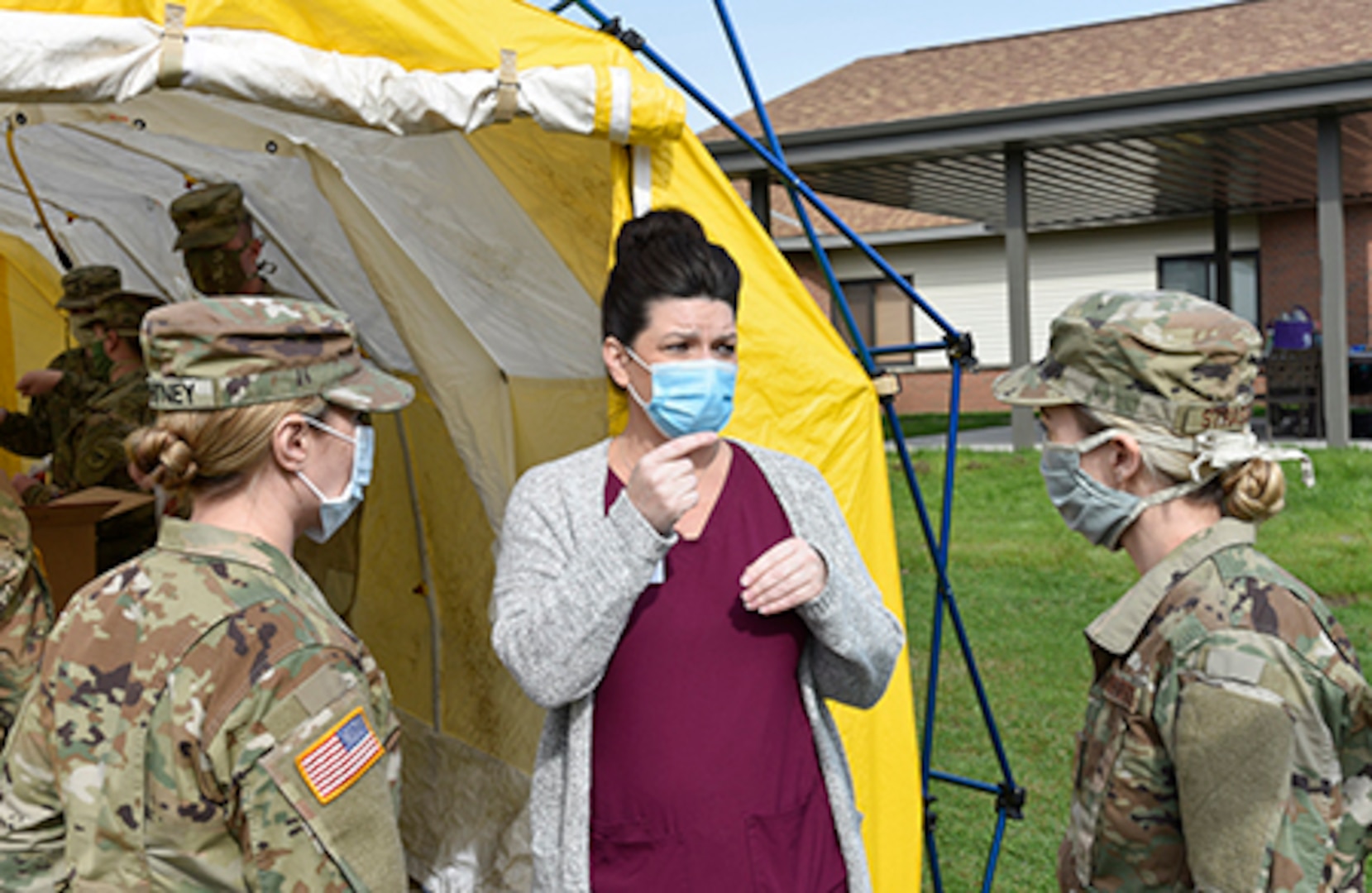 Wisconsin National Guard Soldiers and Airmen talk with a staff member of the Orchard Manor long-term care facility in Lancaster April 25, 2020, about the importance of safely collecting specimens to test residents and staff  for COVID-19.