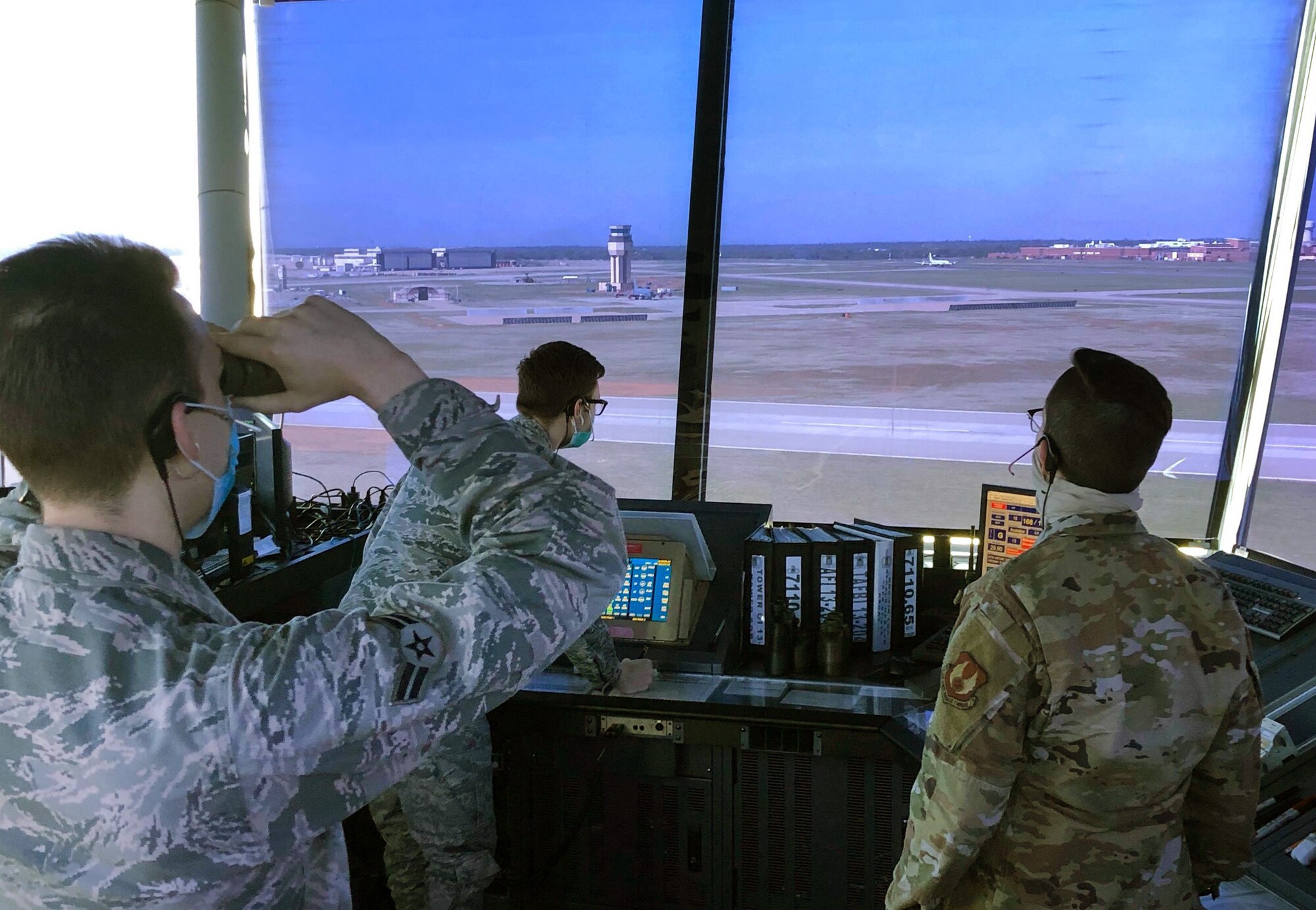Airman 1st Class Christian Thrasher, Airman 1st Class Donald Davis and Senior Airman Kelsi Carney work their shift in the 72nd Operations Support Squadron air traffic control tower. Even though they have to work in a somewhat confined space, they are still managing to follow proper COVID protocols like wearing masks and socially distancing as much as they can.