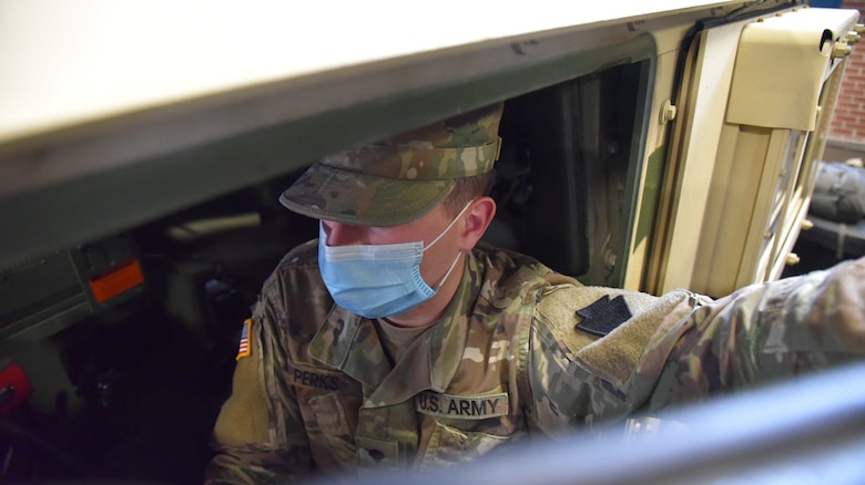 Spc. Matthew Perks sits in his HMMV as he helps check the operating lights of his vehicle during the Pennsylvania National Guard's Covid-19 response on April, 25, 2020. He is part of the Pennsylvania National Guard mortuary affairs and fatality search and recovery team assigned to Task Force Saber preparing for an a mortuary-affairs mission. The mission entails assisting local medical examiners from five Pennsylvania counties – Philadelphia, Chester, Delaware, Bucks, and Montgomery – in the transportation of remains to their central collection locations. (U.S. Air National Guard photo by Master Sgt. George Roach)