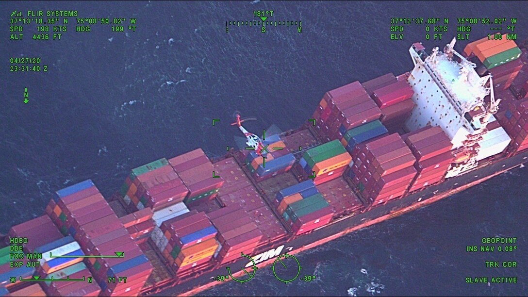 MH-60 Jayhawk helicopter hovers over a container ship