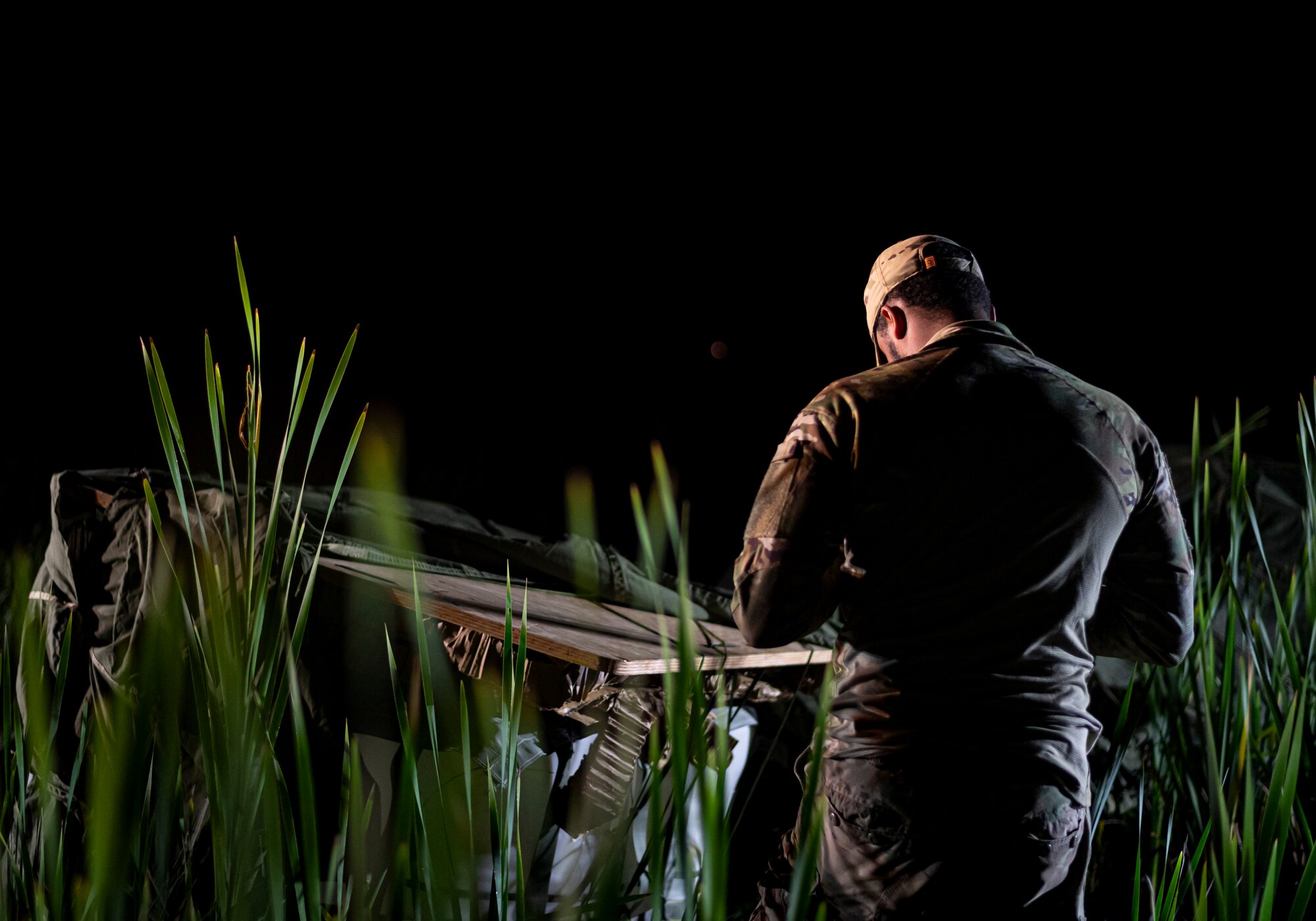 A photo of an Airman looking over cargo