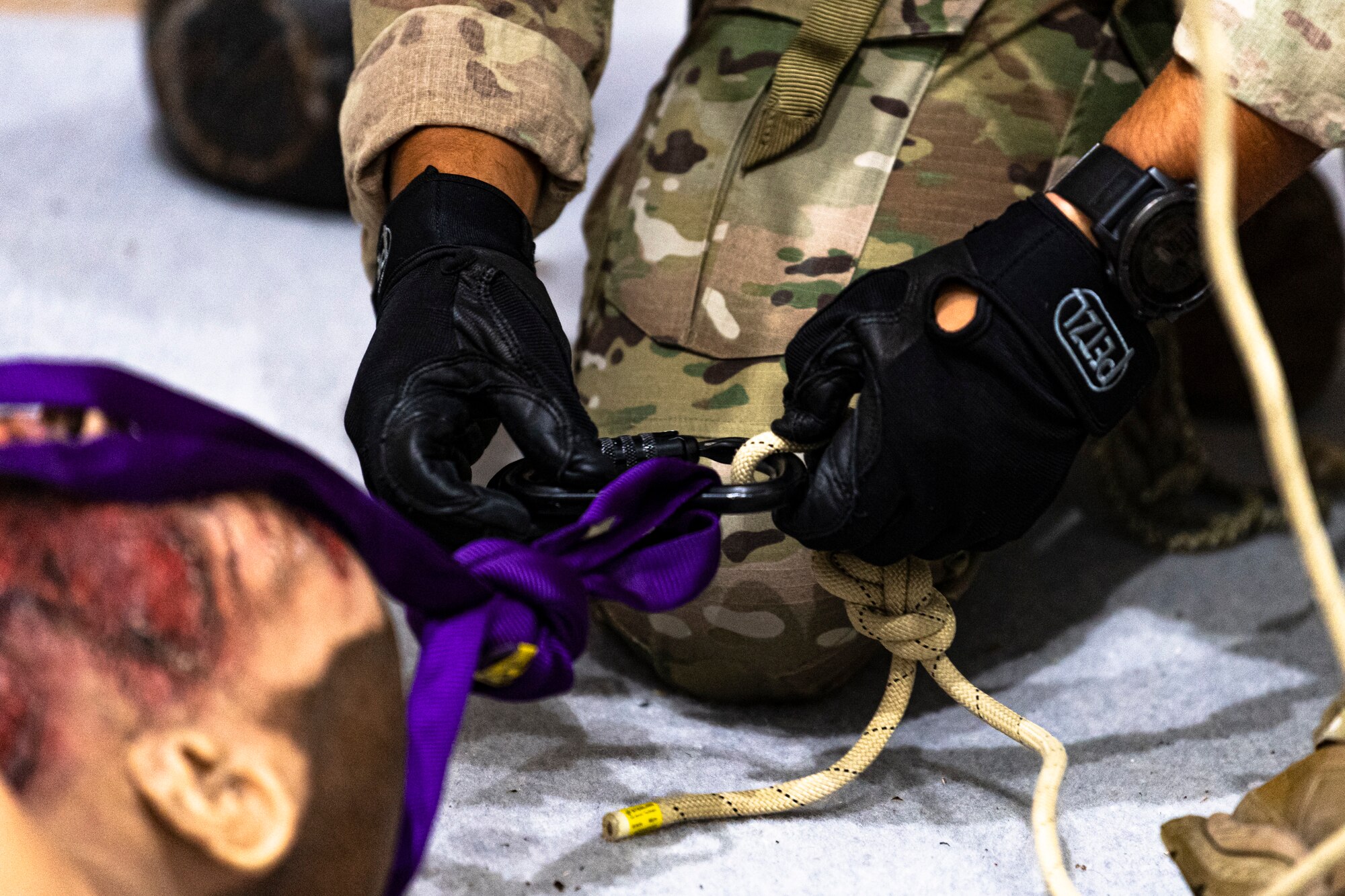 A photo of an Airman securing a simulated casualty to a rope