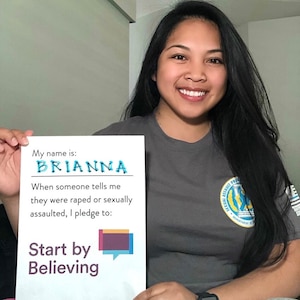 Brianna Sarabia-Templin, volunteer victim advocate, holds a pledge to believe sexual assault survivors.