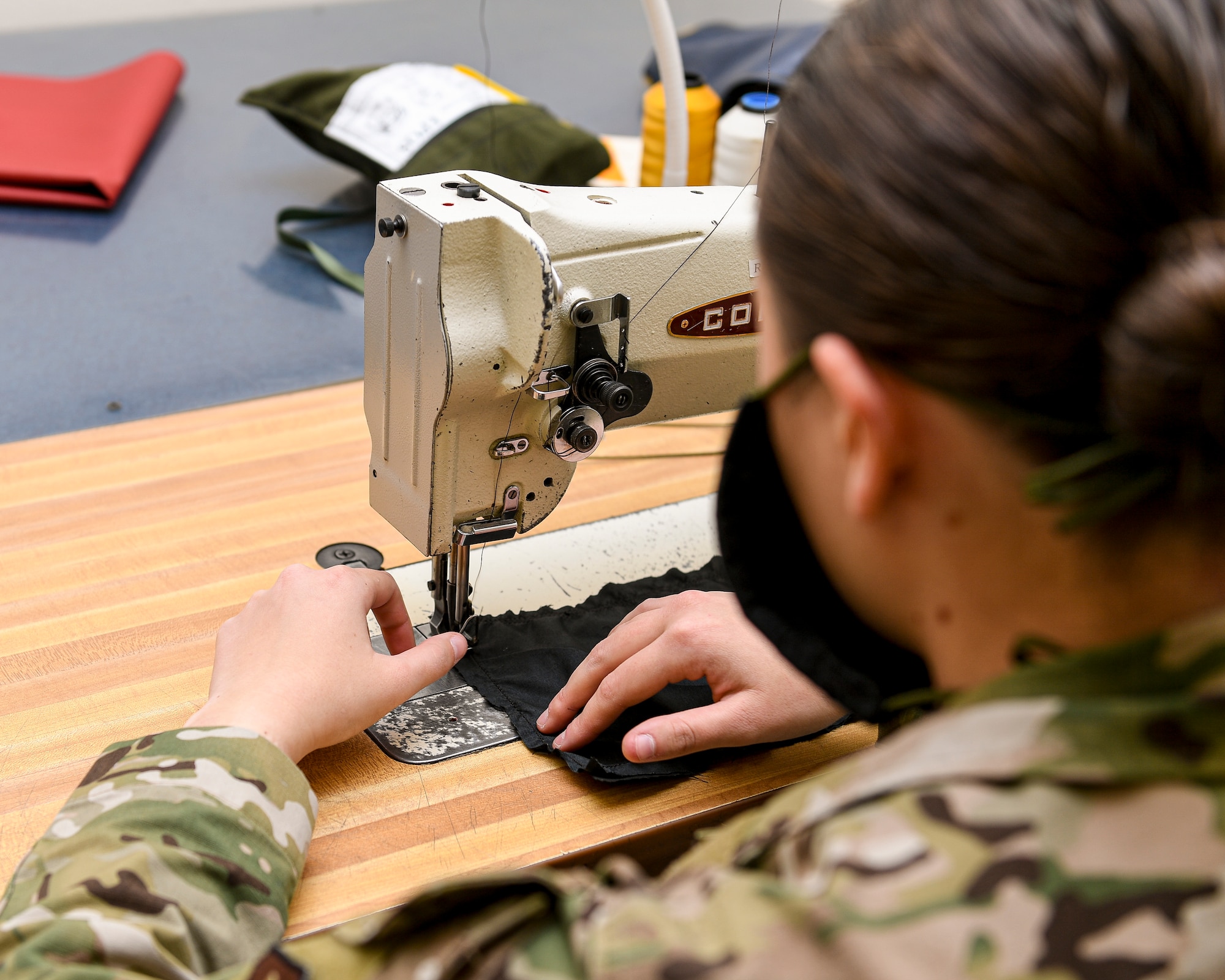 Airman with hands at a sewing machine.