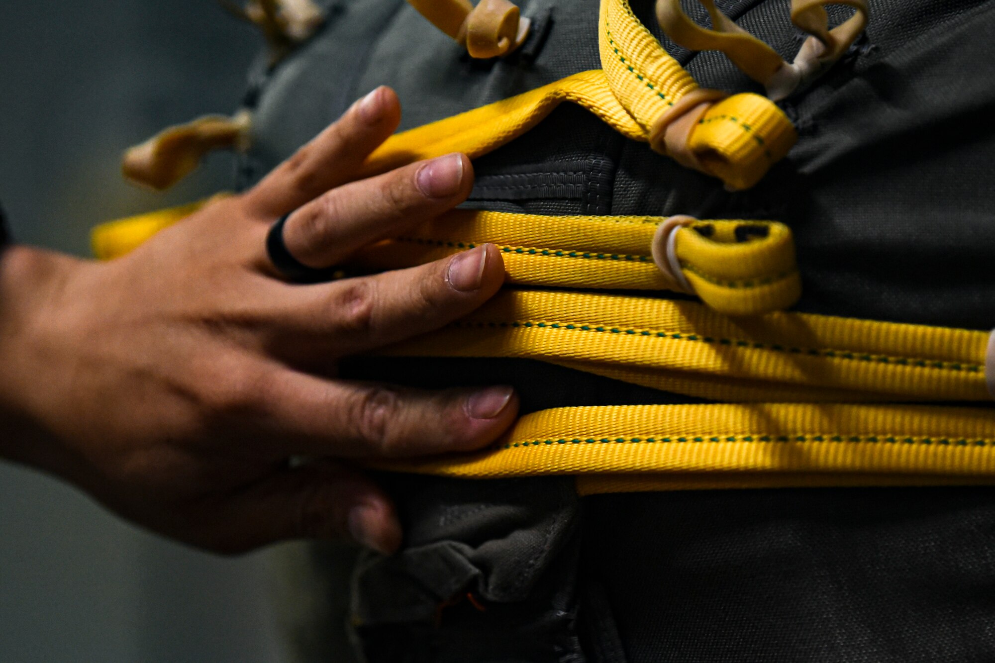 A photo of an Airman looking over a parachute