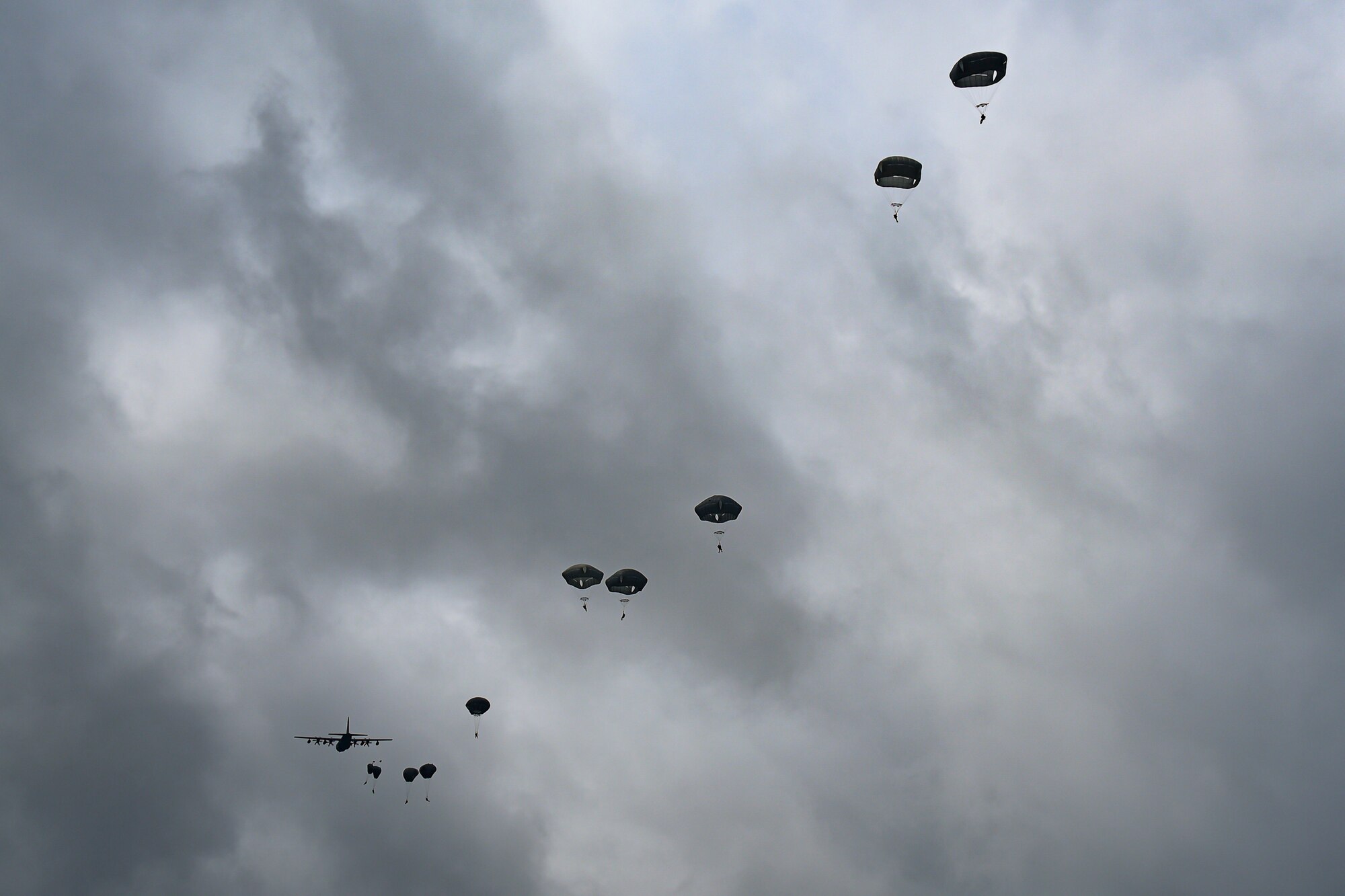 A photo of Airmen jumping out of an HC-130 Combat King II