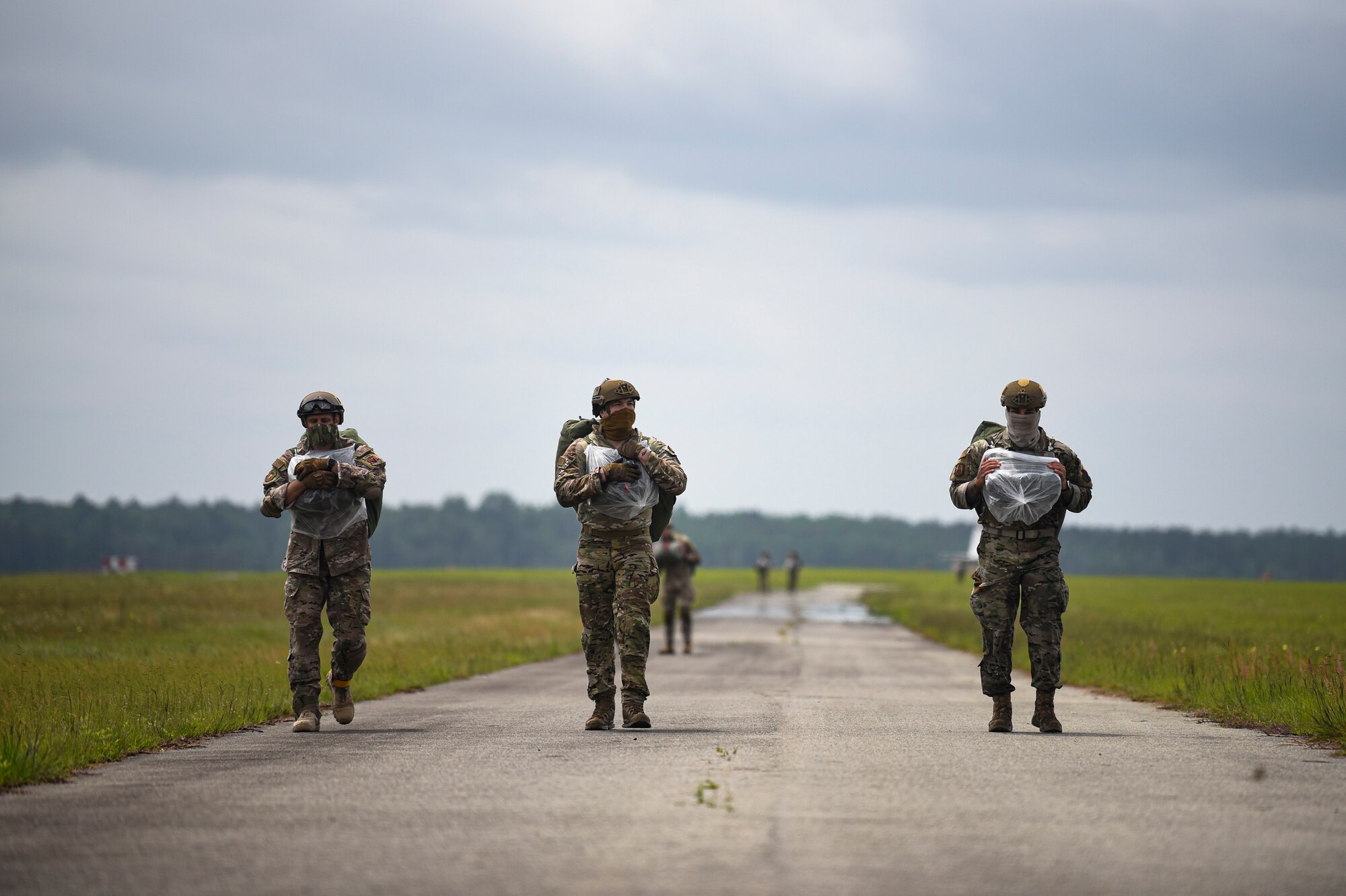 A photo of Airmen walking to a bus after a static-line jump