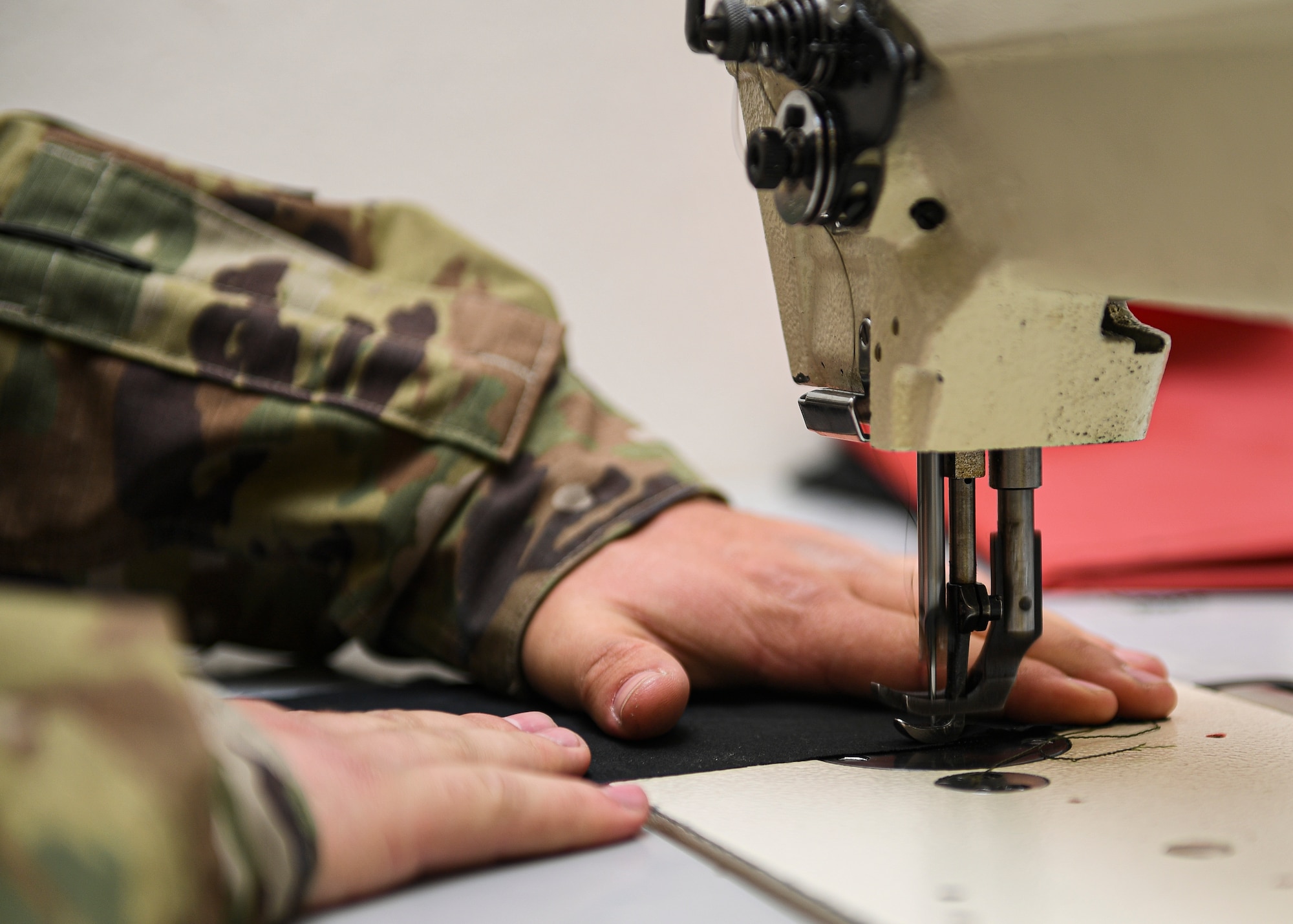Hands of an Airman at a sewing machine