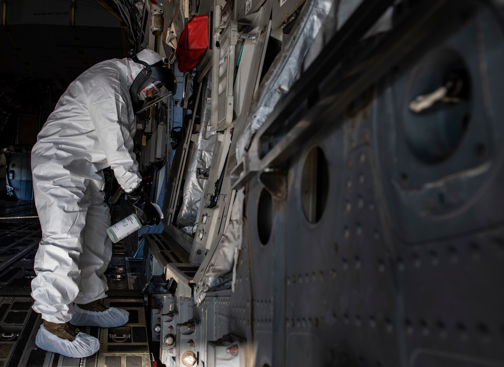 Master Sgt. Jim Puskar, 32nd Aerial Port Squadron fleet services technician, disinfects the inside of a C-17 Globemaster III while wearing personal protective equipment at the Pittsburgh International Airport Air Reserve Station, Pennsylvania, April 15, 2020.