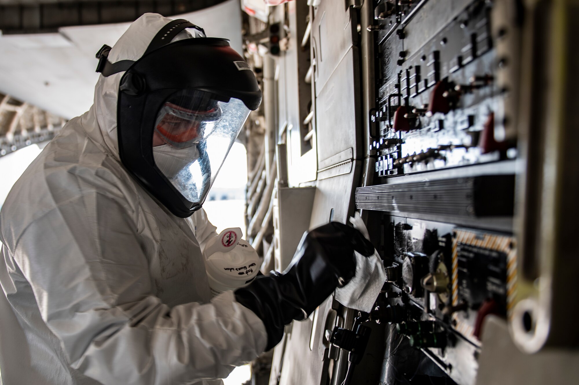 Staff Sgt. John Lundy, 32nd Aerial Port Squadron fleet services technician, disinfects the inside of a C-17 Globemaster III while wearing personal protective equipment at the Pittsburgh International Airport Air Reserve Station, Pennsylvania, April 15, 2020.
