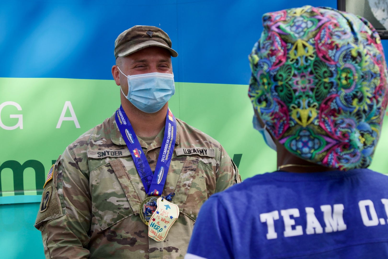 Florida National Guard Spc. Zachary Snyder, 2-124th Regiment 53rd Infantry Brigade Combat Team, receives a donated and decorated medal from a Memorial Healthcare Systems employee at C.B. Smith Park Community- Based Testing Site.