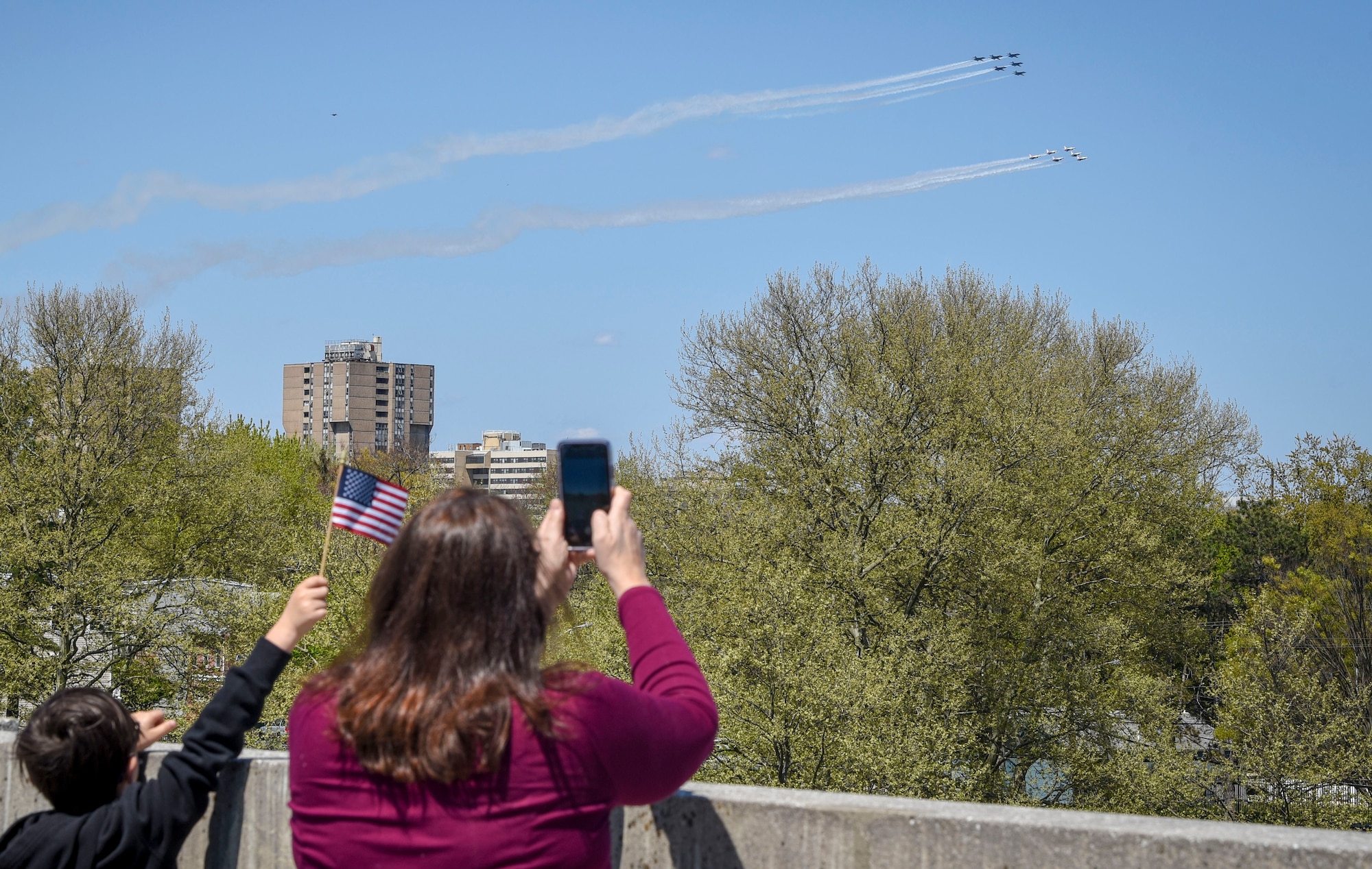 A family watches the U.S. Air Force Demonstration Squadron, the Thunderbirds, and the U.S. Navy Flight Demonstration Squadron, the Blue Angels, during the America Strong flyover at Trenton, New Jersey, April 28, 2020. America Strong is a collaborative salute from the U.S. Air Force and U.S. Navy to recognize healthcare workers, first responders, and other essential personnel while standing in solidarity with all Americans during the COVID-19 pandemic. (U.S. Air Force photo by Tech. Sgt. AJ Hyatt)