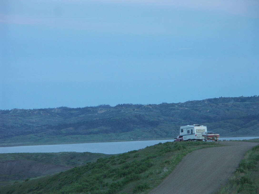 Camper with boat driving into Fourchette Bay on Fort Peck Lake
