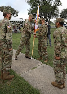 Maj. Gen. Daniel R. Walrath, U.S. Army South commanding general, passes the unit colors to Lt. Col. Mark A. Katz, Headquarters and Headquarters Battalion