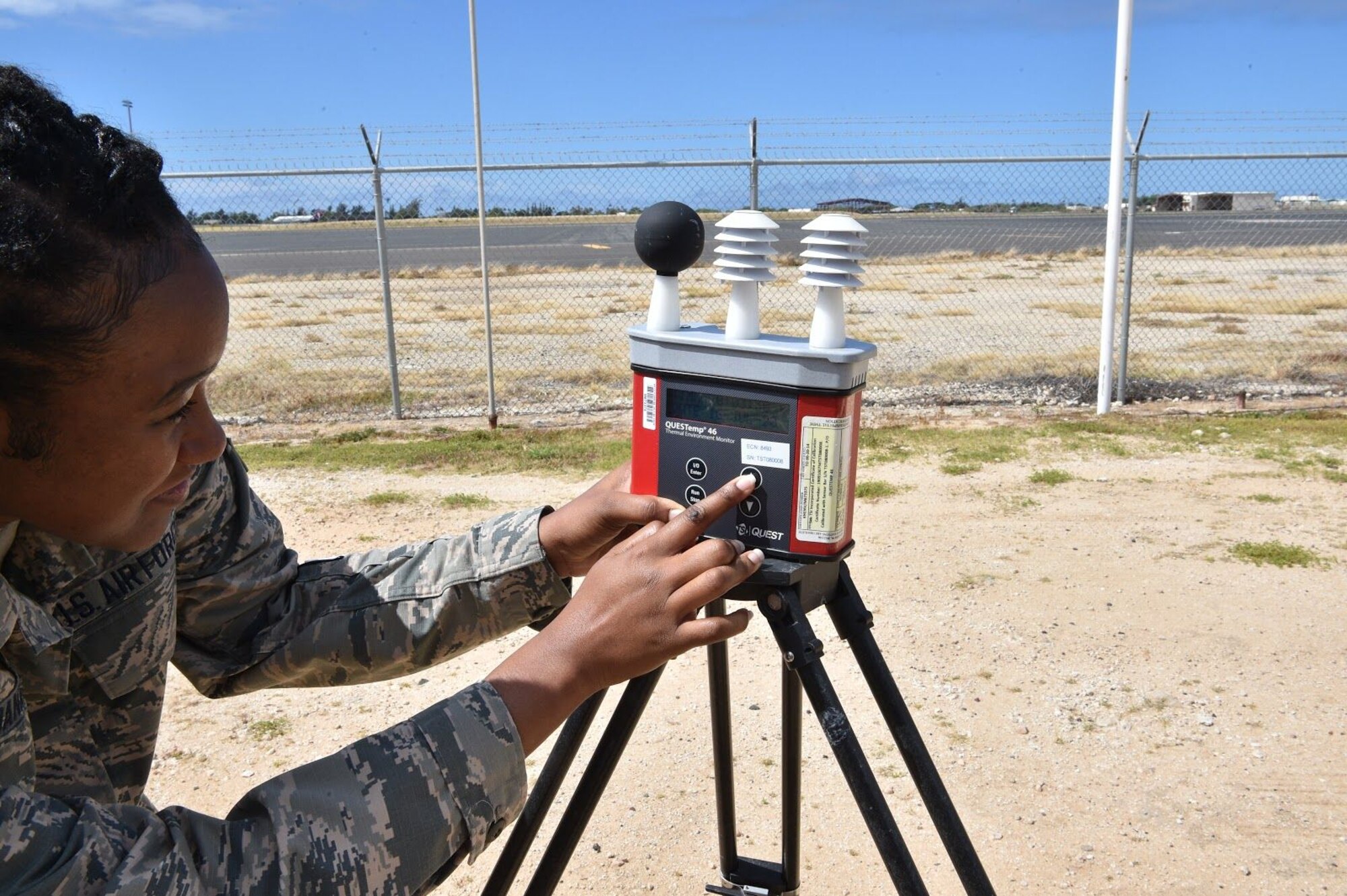 Senior Airman Erica Daniels, 15th Medical Group Bioenvironmental Engineering Flight bioenvironmental engineering technician, checks the Wet-bulb Globe Temperature readings to determine environmental hazards for Airmen at Joint Base Pearl Harbor-Hickam, Hawaii, July 16, 2020. The three sensors on top, from left to right, measure the Globe Bulb temperature, the Natural Wet Bulb temperature, and the Dry Bulb temperature. (U.S. Air Force Photo by 2nd Lt. Benjamin Aronson)