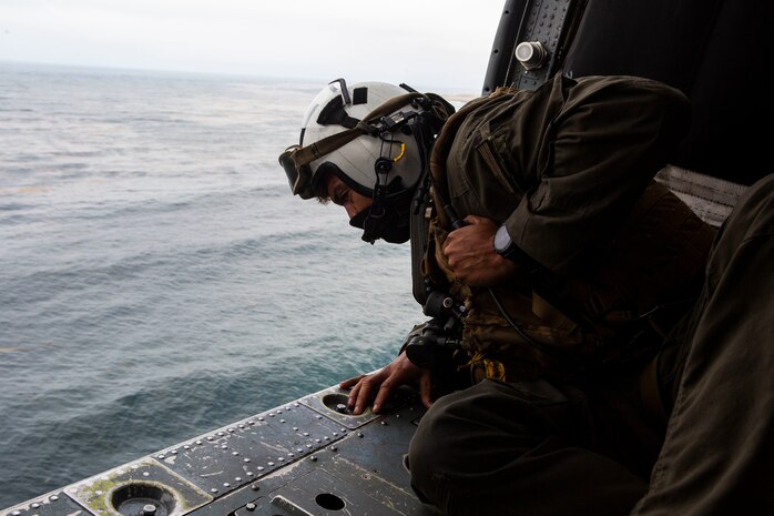 Naval Air Crewman 2nd Class Joseph Rivera, a search and rescue swimmer assigned to the amphibious assault ship USS Makin Island, looks out of a U.S. Navy MH-60 Seahawk while conducting search and rescue relief operations following an AAV-P7/A1 assault amphibious vehicle mishap off the coast of Southern California, July 30, 2020. Assisting in the search and rescue relief operations are the guided-missile destroyer USS John Finn, multiple U.S. Navy MH-60 helicopters and small boats from USS Makin Island, the amphibious transport dock USS Somerset, the amphibious transport dock USS San Diego, as well as the U.S. Coast Guard Cutter Forrest Rednour and a Coast Guard MH-60 Jayhawk helicopter from Coast Guard Sector San Diego.