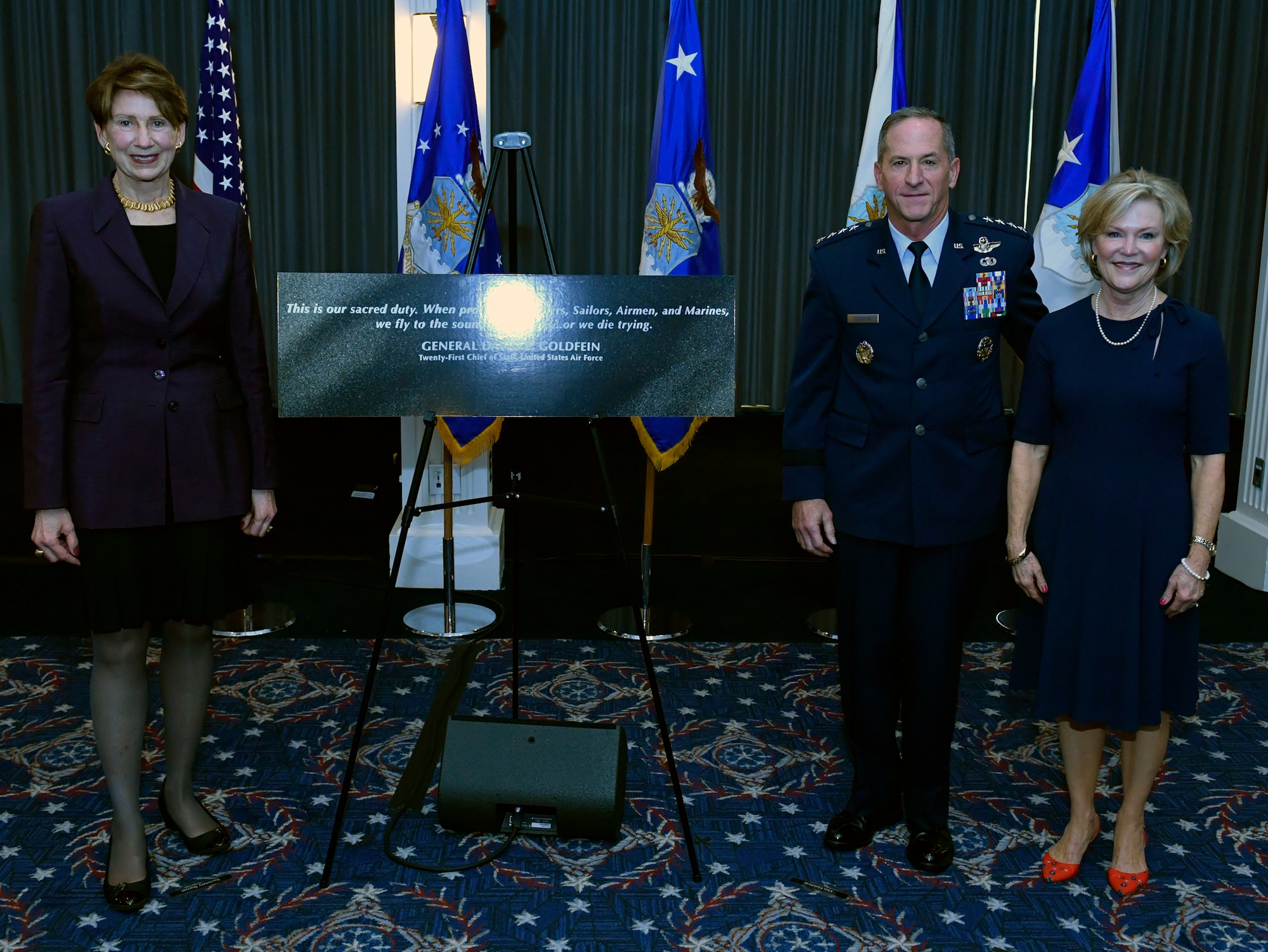 Secretary of the Air Force Barbara M. Barrett, left, Air Force Chief of Staff David L. Goldfein and Mrs. Dawn Goldfein pose with a representation of an etching that is now displayed on the Wall of Valor at the Air Force Memorial during a ceremony at Joint Base Anacostia-Bolling, Washington, D.C., July 31, 2020. The ceremony unveiled a new etching for the memorial's Wall of Valor at the Air Force Memorial that reads, "This is our sacred duty. When protecting Soldiers, Sailors, Airmen and Marines, we fly to the sound of the guns … or we die trying." (U.S. Air Force photo by Wayne Clark)