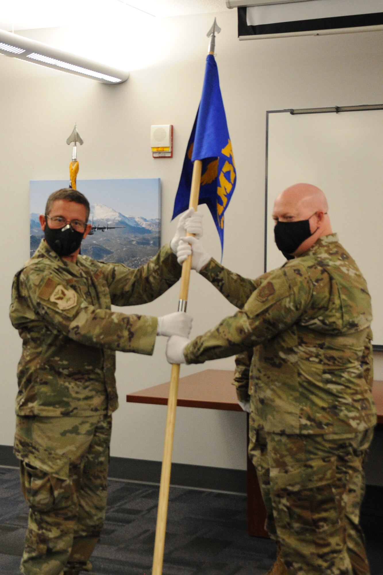 Col. Jordan Murphy, 302nd Maintenance Group commander, passes the 302nd Aircraft Maintenance Squadron guidon to Lt. Col. Cody Whittington during a change of command ceremony.
