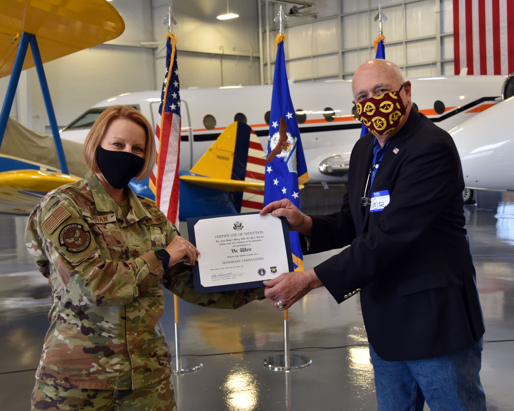 301st Fighter Wing Maintenance Squadron Commander Maj. Jennifer Trahan presents her MXS Honorary Commander Mr. Vic Weir an official certificate at the 301 FW Honorary Commander Induction Ceremony at Alliance Airport on July 31, 2020. Weir is one of the 17 wing honorary commanders. (U.S. photo by Senior Airman Kedesha Pennant)