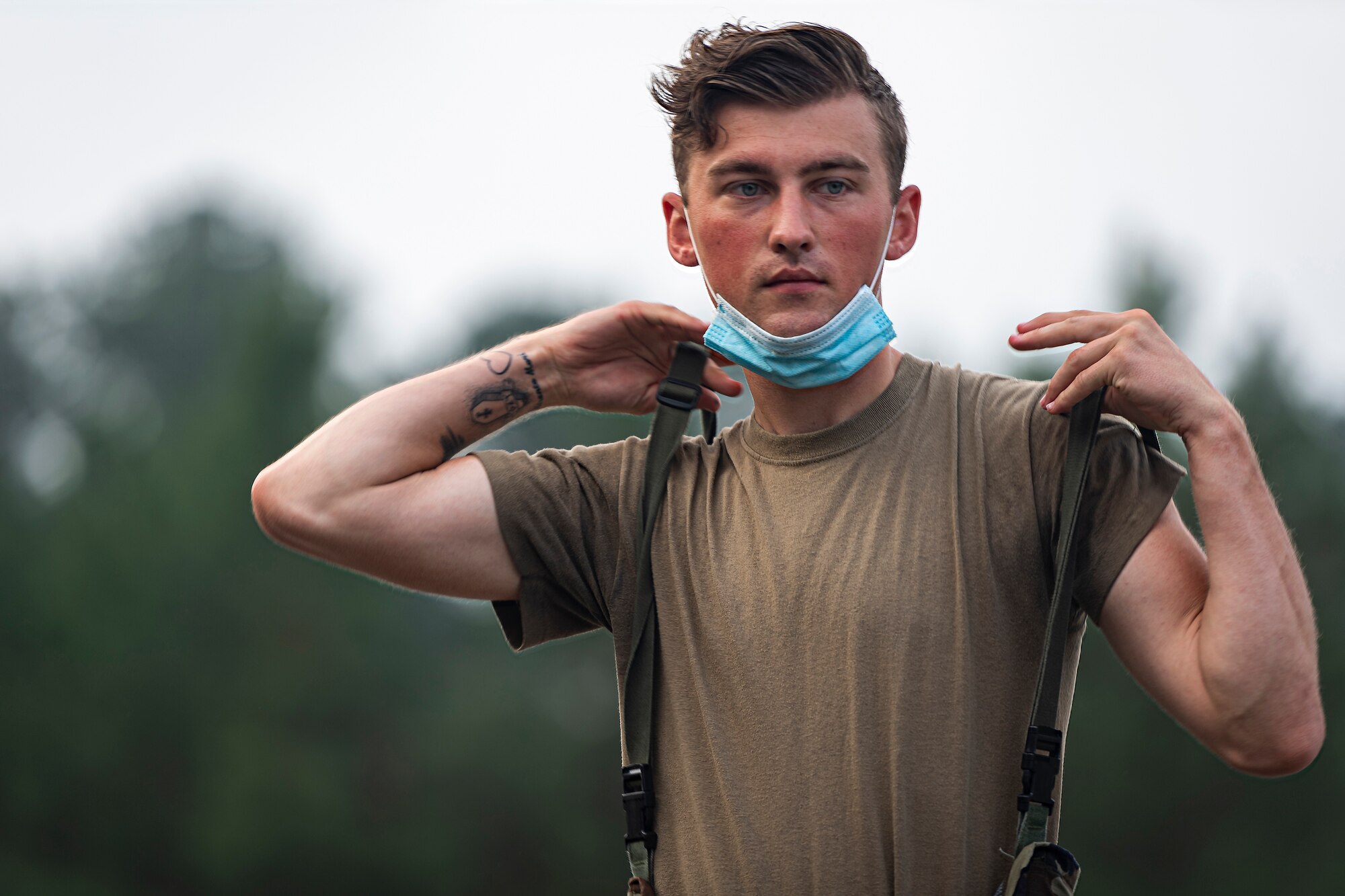 A photo of an Airman donning MOPP gear.