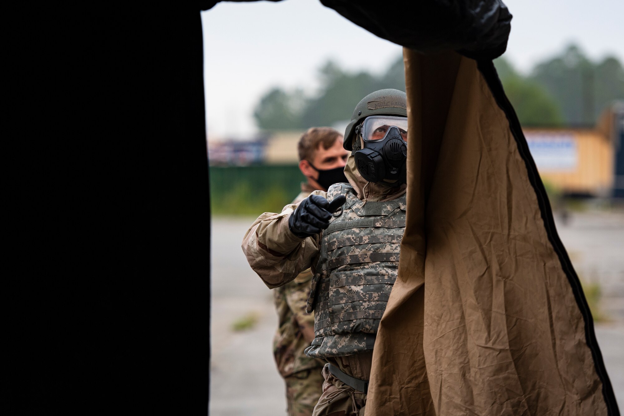 A photo of an Airman removing a flap from a folding frame shelter.