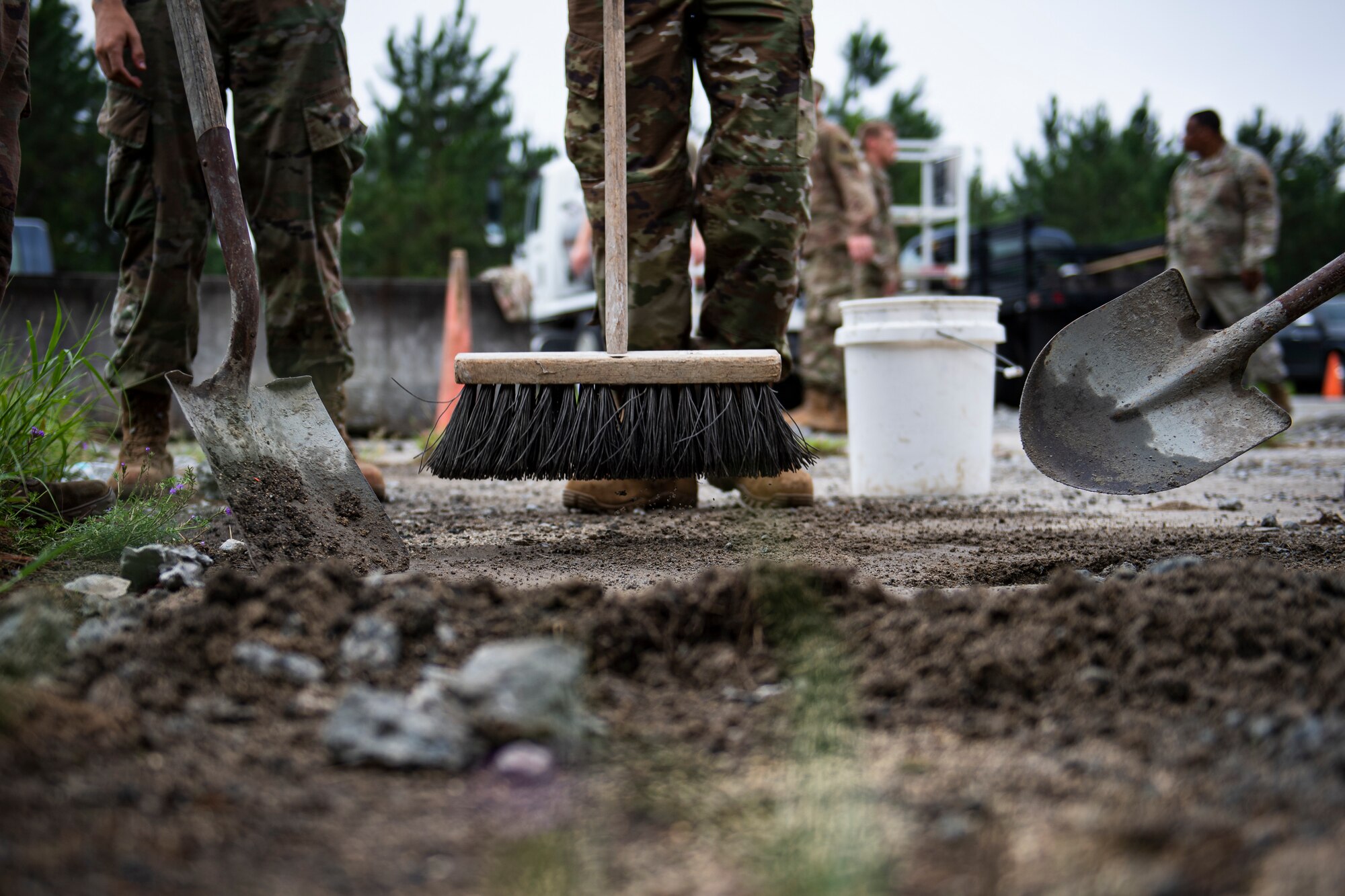 A photo of Airmen cleaning debris from a spall.