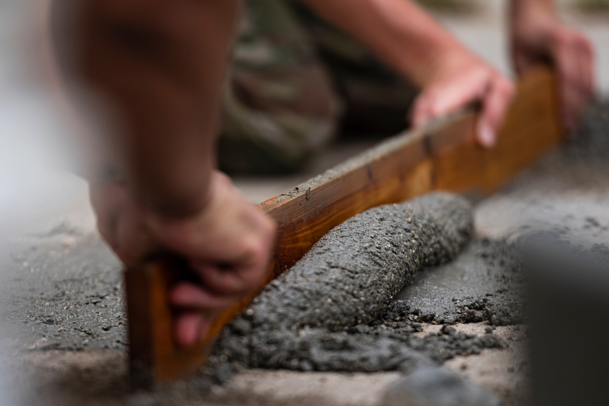 A photo of Airmen leveling wet concrete.