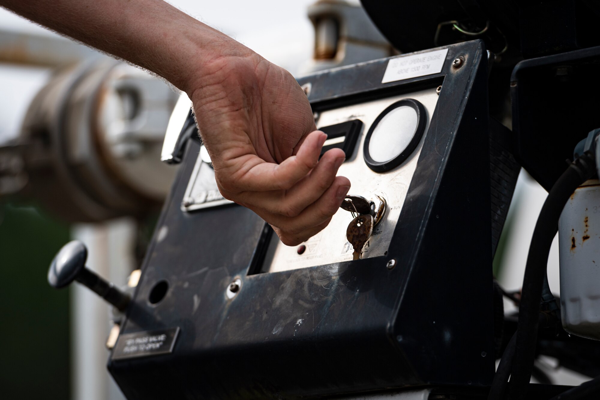 A photo of an Airman turning a key on a water truck.