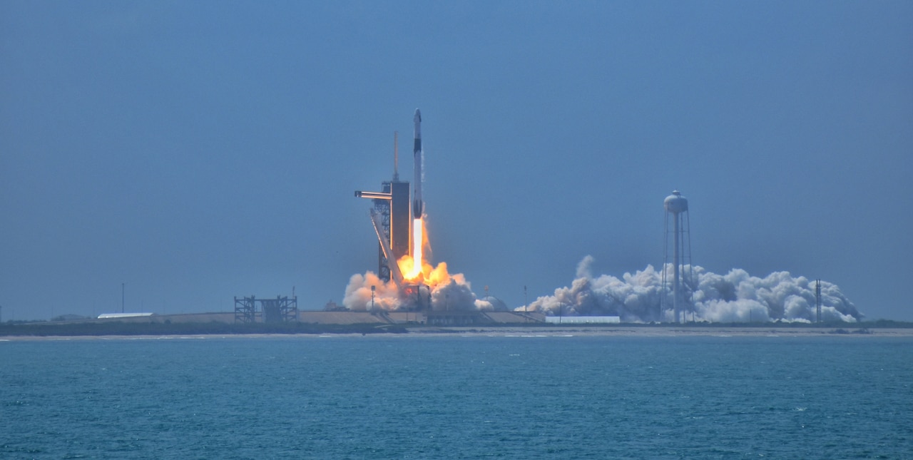 A rocket lifts off from a launch pad.