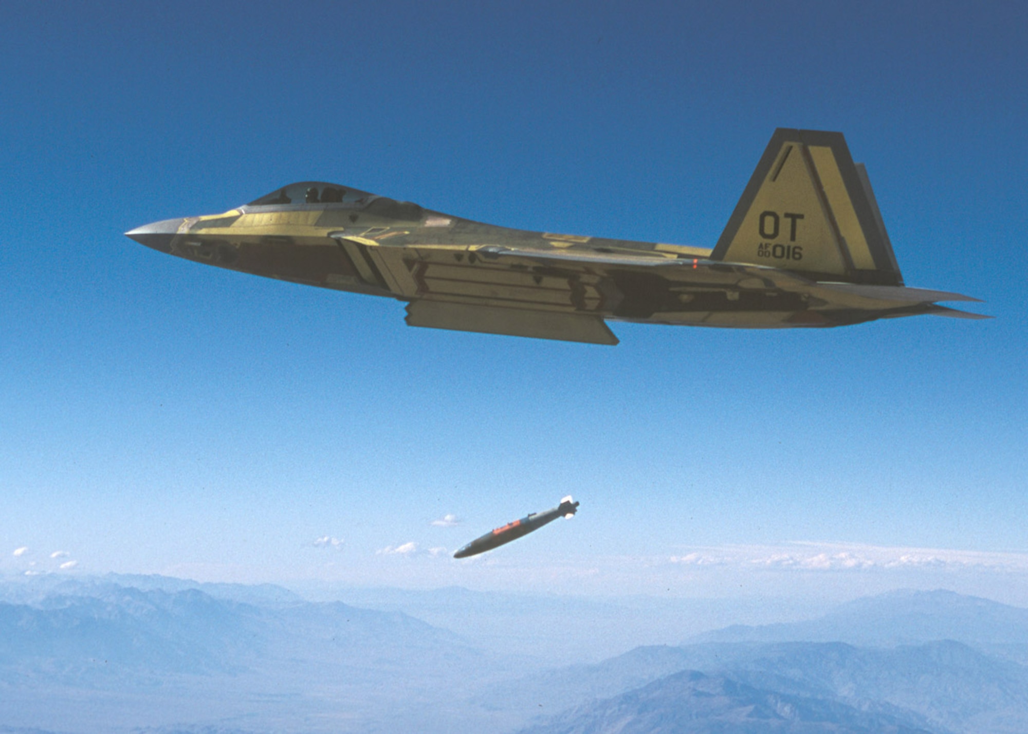An F/A-22 drops a 1,000-pound GBU-32 JDAM at Edwards AFB, successfully hitting its designated ground target. Photo by Kevin Robertson