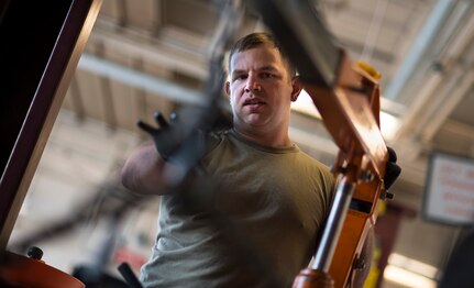 U.S. Air Force Staff Sgt. Bob Osborn, a ground transportation specialist assigned to the 181st Intelligence Wing, Indiana Air National Guard, gestures toward an engine hoist while performing vehicle transmission maintenance at Hulman Field Air National Guard Base, Ind., July 31, 2020. Osborn assists with vehicle maintenance and repair in addition to his ground transportation duties.